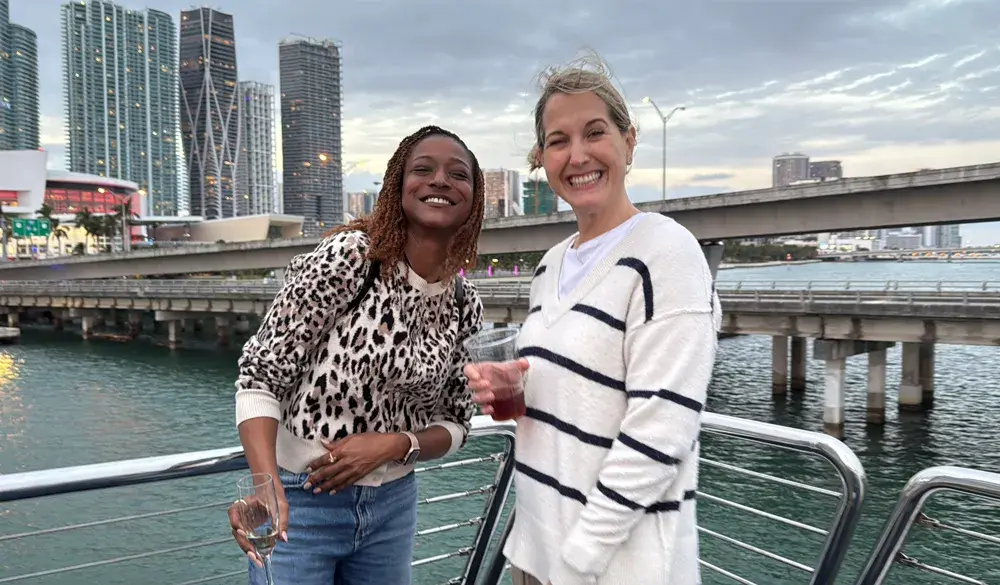 Two smiling Pricefx employees meeting at the January 2025 Sales Kick Off event in Miami
